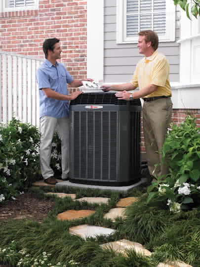 trane dealer handing brochure to client next to ac unit