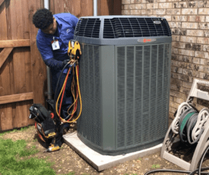 freedom heating and air hvac technician inspecting a trane hvac system with guages